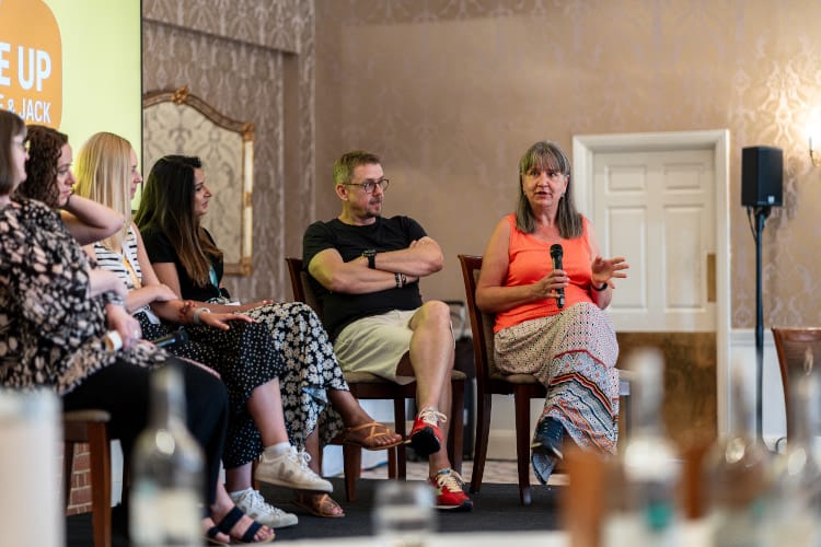 Sarah answering a question in a panel session on stage.